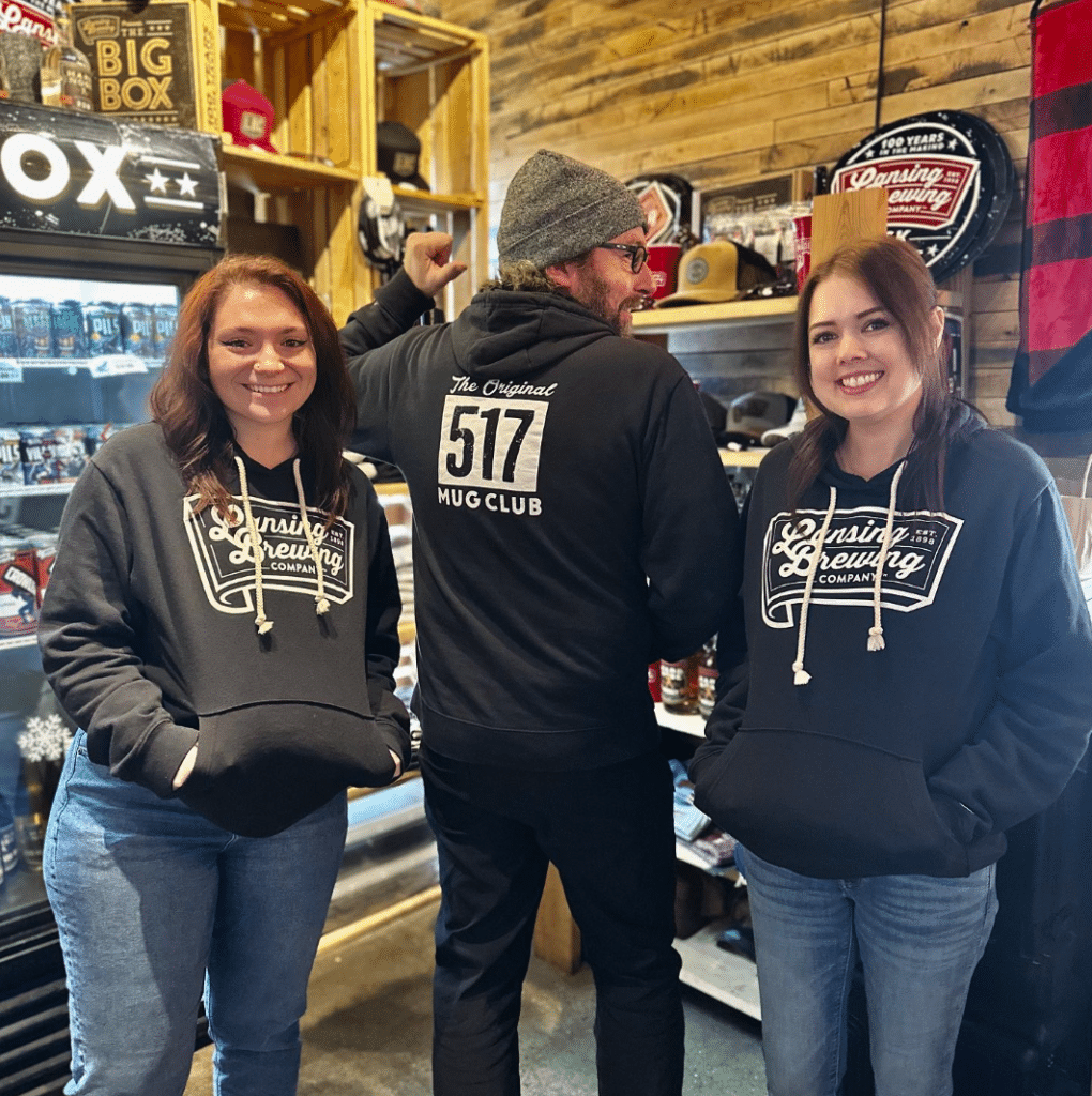 3 Lansing Brewing Company staff members wear 517 Mug Club sweatshirts